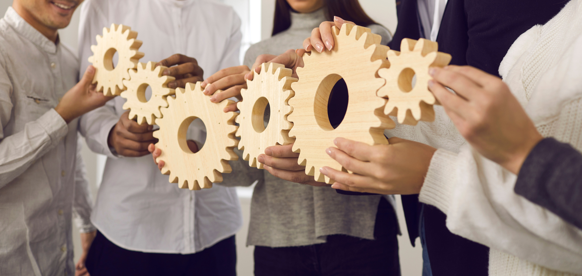 Group of People Joining Gears as Metaphor for Collaboration and Building Effective Business System